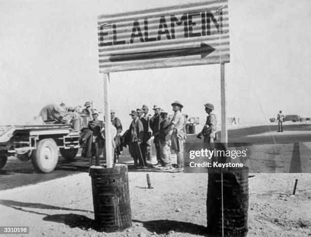 German prisoners from the Afrika Korps passing a sign to El Alamein in the north African desert, Egypt, after the Battle of El Alamein.