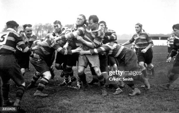 Bath backs attacking a Richmond forward during their rugby match.