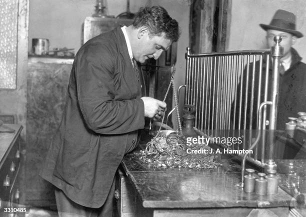Mr Abelson examining some of the gold articles he purchased from the public, after the lifting of the Gold Standard in Britain led to hundreds of...