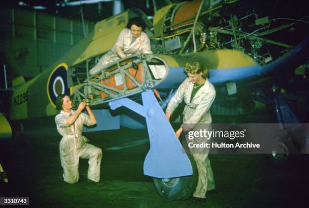 Engineers mending a Hawker Hurricane aircraft.