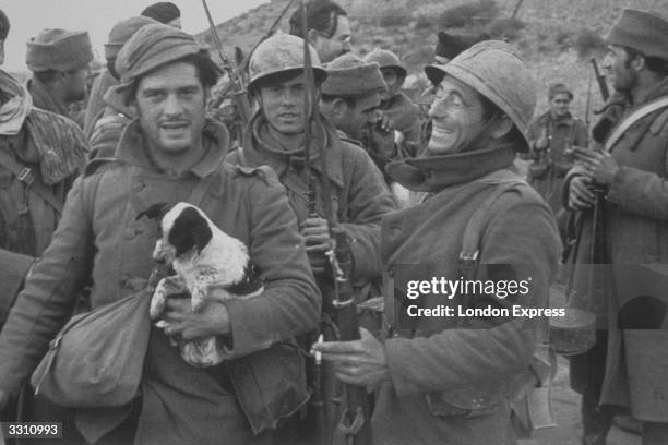 Reporters at the front line with Spanish Republican troops. Ernest Hemingway can be seen in the background.