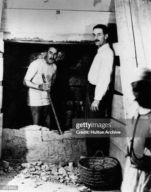 English egyptologist Howard Carter and Mr Mace opening the wall of the inner chamber of Tutankhamen's tomb.