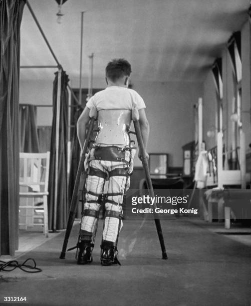 Child suffering from Infantile Paralysis learning to walk with the aid of a special support, at Queen Mary's Hospital, London.