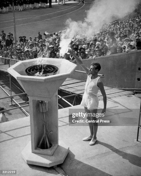 British athlete John Mark lights the Olympic Flame at the opening ceremony of the Olympic Games at Wembley Stadium, London.