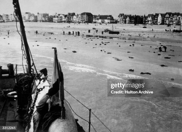 Scene on the beach at Dunkirk, after a Nazi attack on French and British troops. Many men threw their coats and equipment onto the sand before...