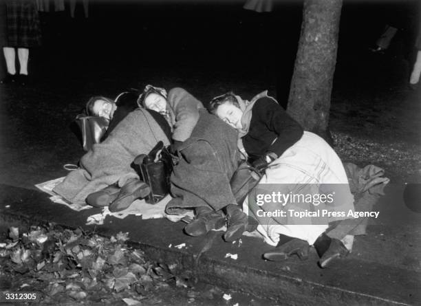 Three girls sleeping out overnight in London to secure a position from which they hope to see the royal wedding procession of Princess Elizabeth and...