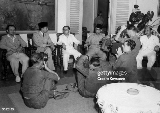 Indonesian President Dr Sukarno, , and members of his government face British cameramen after a cabinet meeting held in the President's Batavia...