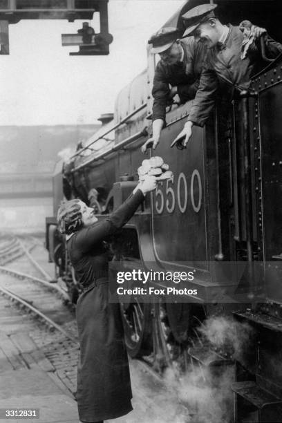 Train drivers being served hot cross buns at Euston Station, London.