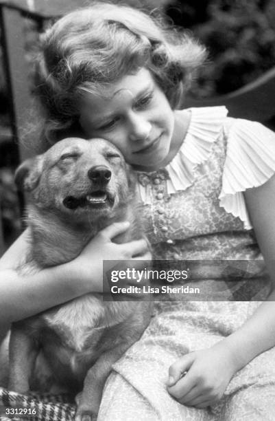 Princess Elizabeth hugging a corgi dog.