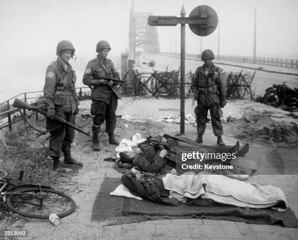 German wounded taken prisoner after the battle of Nijmegen Bridge, Holland. The US airborne division are on guard.