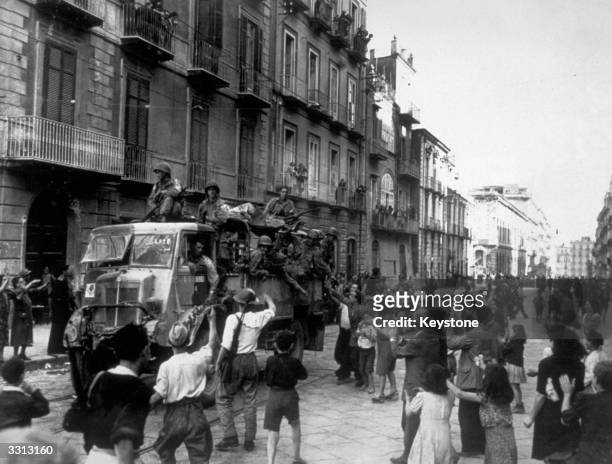 American troops travelling through Naples in British trucks on their way to the front are given a warm welcome by the Neapolitans.