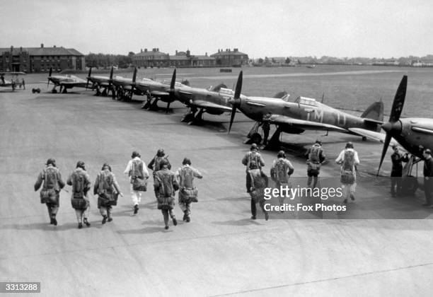 Pilots of No.111 Squadron Royal Air Force Fighter Command make a practice scramble to board their Hawker Hurricane Mk1 monoplane fighters with their...