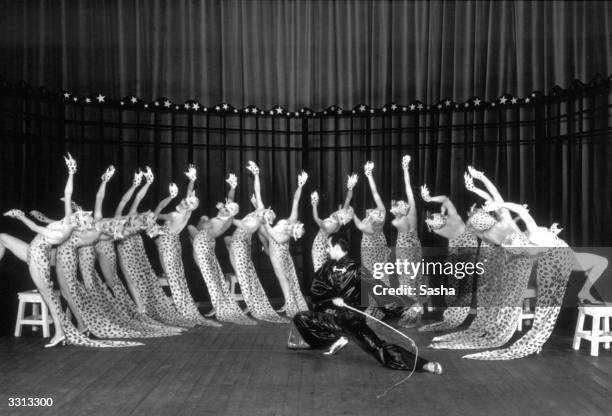Scene from the show 'Round About Regent Street', with a ringmaster training a group of leopard women.