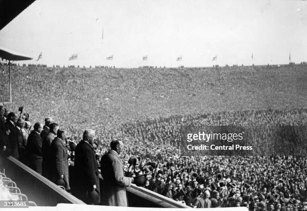 King George V and a huge crowd attend the first FA Cup Final to be held at Wembley Stadium, London, between West Ham United and Bolton Wanderers....
