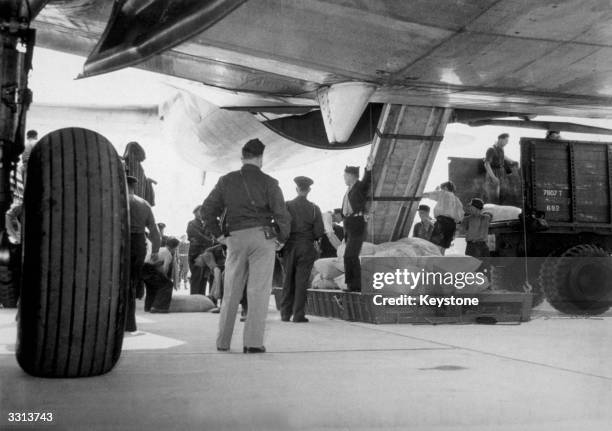 An American transport plane, taking part in the Berlin Airlift, at Gatow Airport having just landed with 23 tons of flour for the Berlin population,...
