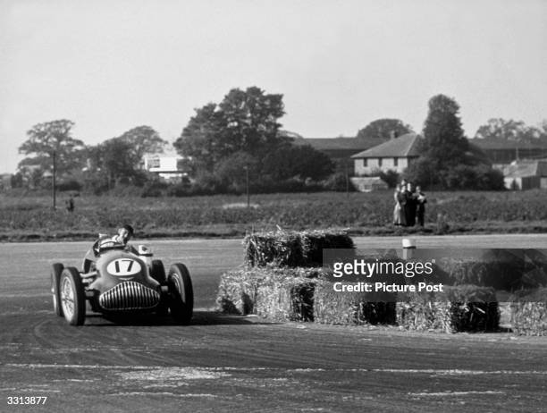 George Watson of Great Britain drives the Alta69/IS during the RAC International Grand Prix at Silverstone, a former bomber airfield. This is the...