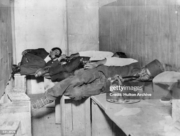 Three men relaxing and smoking opium.