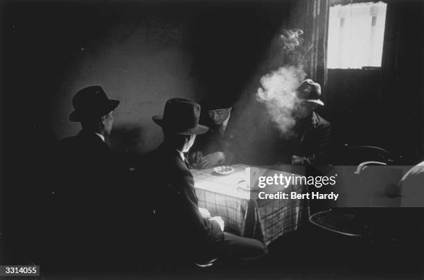 Smoke-filled room in a Chinese hostel in Liverpool. Original Publication: Picture Post - 1136 - Chinese Hostel, Liverpool - unpub.