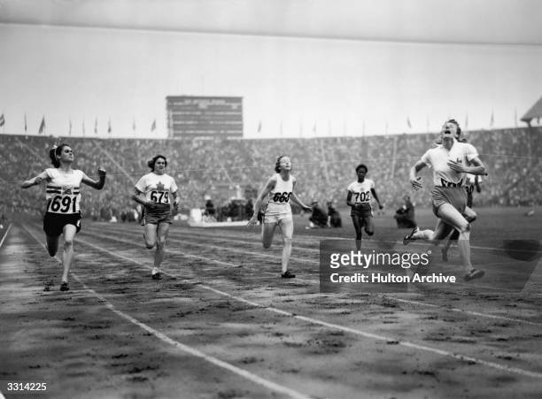 The finish of the women's 100 metres Olympic final at Wembley, London, won by Fanny Blankers-Koen of Holland. On the left, number 691, is silver...