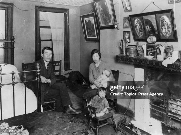 Family in their room in a Lisburn Street tenement house in the Bethnal Green, east London, slum area.