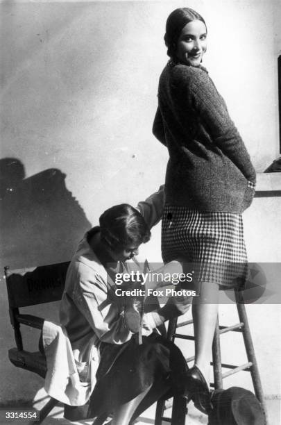 Woman having a seam painted onto her leg, to make it appear that she is wearing stockings.