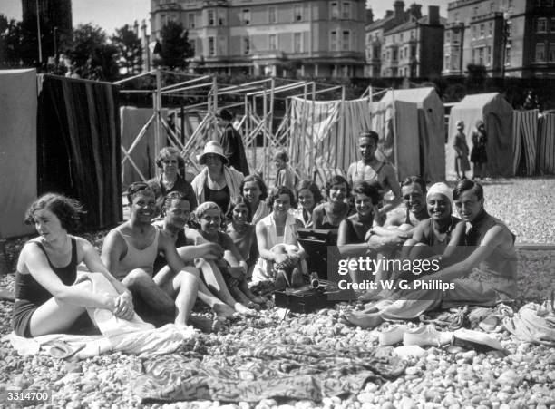 Holidaymakers on the beach at Eastbourne, listening to their gramophone in the July sunshine.