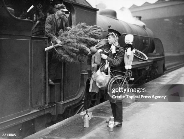 Train driver handing a Christmas tree, one of the many items left on the train, to a guard at Waterloo station.