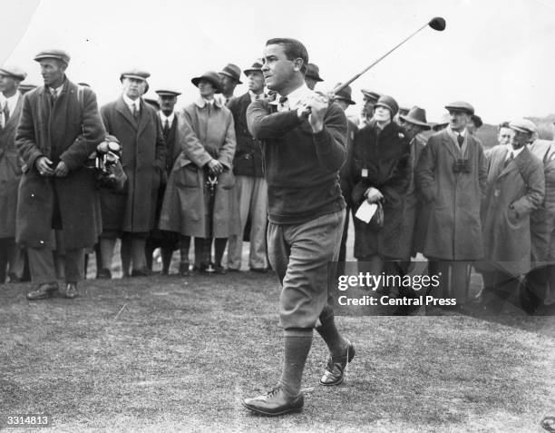 Golfer Gene Sarazen of the USA taking a shot, surrounded by spectators.