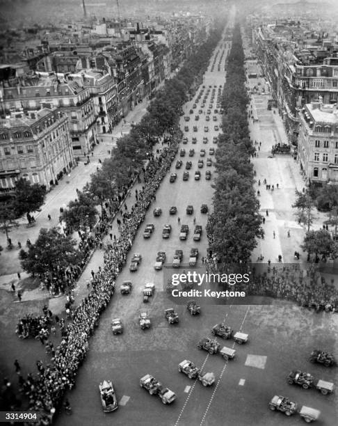 Parisians line the Champs Elysees to cheer the parade of soldiers towards the Arc de Triomphe after the liberaton.