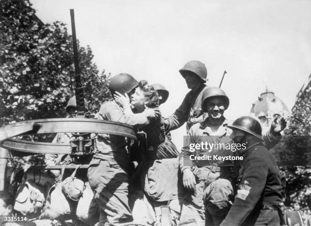 Parisian girls welcome the liberating US troops arriving in Paris.