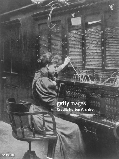 An operator at the distant-message wires, in the telephone exchange in Manchester.