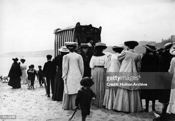 Crowds gather to watch a Punch and Judy puppet show on the beach at Scarborough.