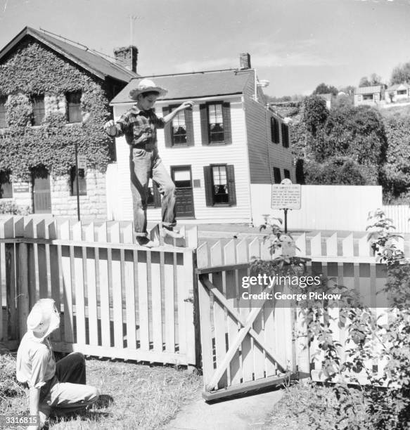 Young Mississippi boy balances on the most famous fence in American fiction. It is in front of Mark Twain's house and is supposed to be the one Tom...