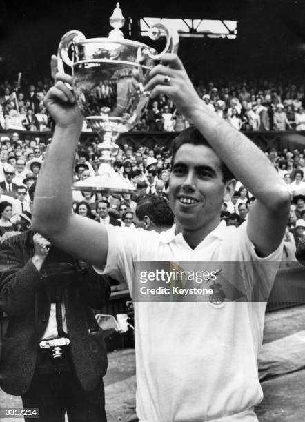 Spanish tennis player Manuel Santana holding the cup in triumph after beating Dennis Ralston of the United States in the Men's Singles Final at...