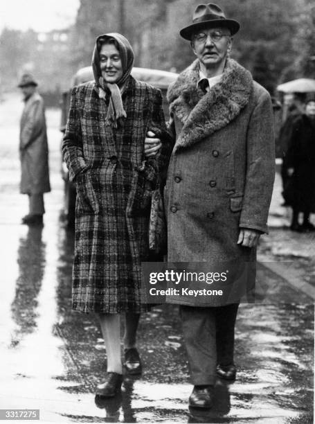 German financier Dr Hjalmar Schacht in Nuremberg, in the rain with his wife after his release.