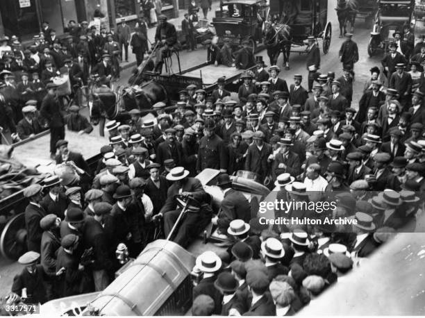 Crowd gathers round Jack Johnson of the USA as he arrives in his car in Fleet Street. One of the greatest yet most unpopular Heavyweight boxers of...