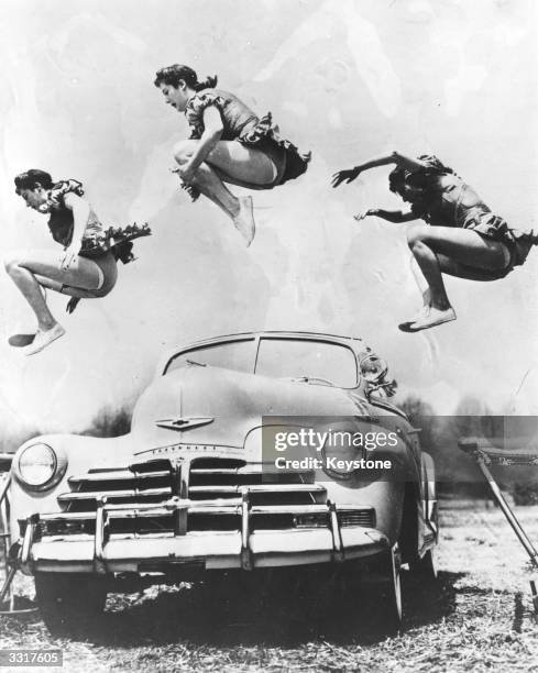 Heather Pugh of Cole Brothers Circus jumps over a Chevrolet car.