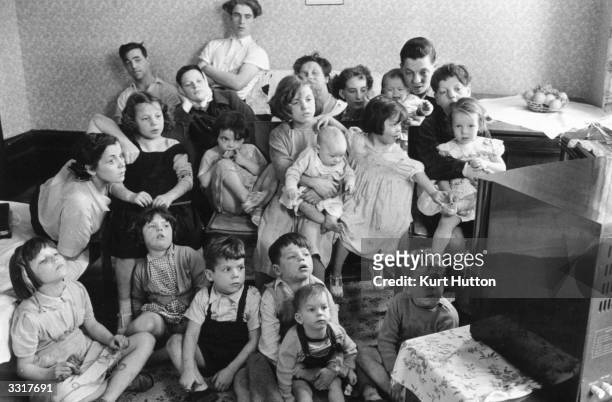 Charles and Elizabeth Hudson watching television with some of their twenty children and six grandchildren, in their eight-room Victorian house in...