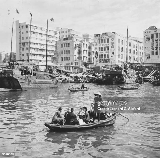 Group of people being ferried across a stretch of water in Hong Kong.