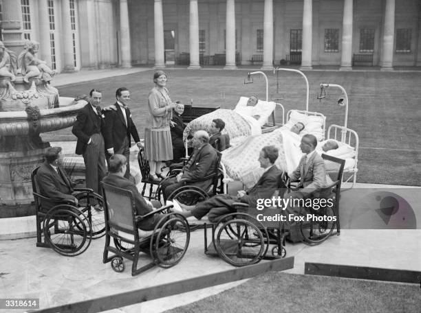 Miss Wynne singing to wounded soldiers in the hospital grounds.