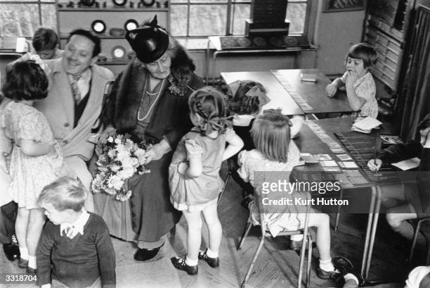 The founder of the Montessori Schools, Maria Montessori in a classroom in Acton, London with a group of children. Original Publication: Picture Post...