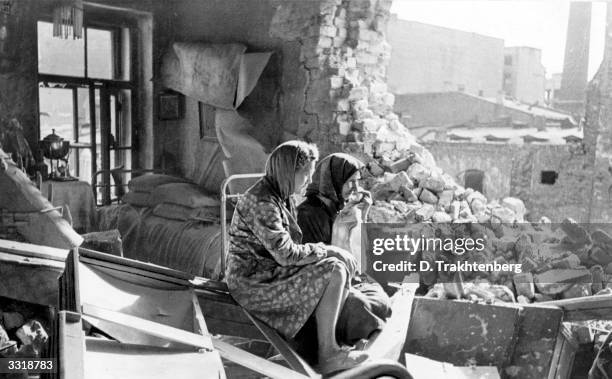 Two women sitting among the debris in the aftermath of the German bombardment of Leningrad. Trying to compel the Russian defenders to surrender, the...