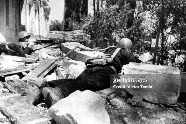 Two Russian soldiers positioned amongst the rubble in the defence of Stalingrad, Russia.