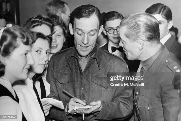 Uniformed comedian Tommy Trinder giving his autograph at a Home Guard celebration.