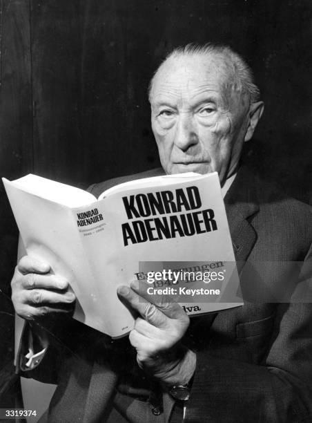 German statesman and three times chancellor, Konrad Adenauer, holding his recently published memoirs, shortly before his 90th birthday.