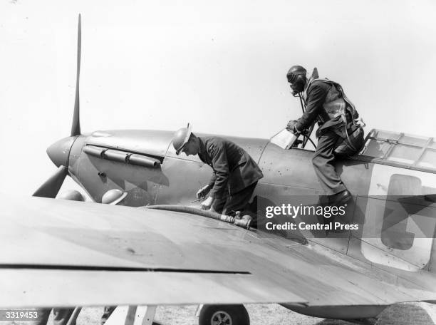 Hurricane is refuelled at a Royal Air Force Fighter Station and the pilot leaves the cockpit to report to the squadron intelligence officer during...