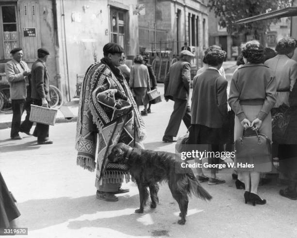 Frenchman carrying rugs in the market at Montrevel, nr Lyons, France. There are only a few market days a year and they are considered 'grand events'.