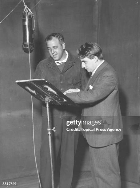 American tenor Richard Crooks, who is in England to record for the 'His Master's Voice' Gramophone Co, and English conductor John Barbirolli standing...