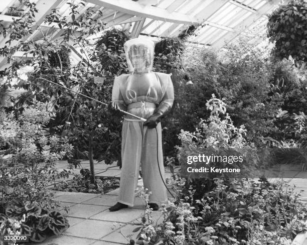 Sophia Pienkos, a gardener at London's Royal Botanical Gardens in Kew, wearing a new space-age, see-through PVC suit for protection when using toxic...