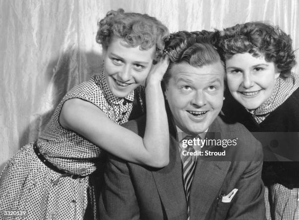 British comedian Benny Hill gets friendly with Joyce Allan and Moyra Delare.